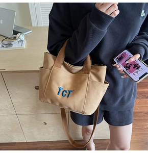 Détail du sac cabas en toile marron avec broderie TCT bleue et poche latérale