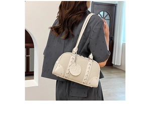 Detailed view of beige lychee leather Boston bag with braided ropes and metal rivets