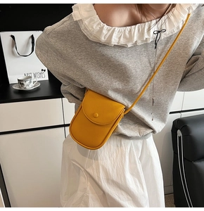 Détail de la pochette de téléphone jaune en cuir grainé avec rabat à fermoir magnétique