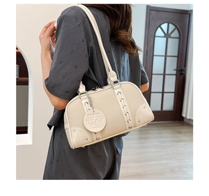 Close-up of beige boston bag with litchi texture and braided leather details