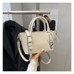 Détail du sac seau en cuir grainé blanc crème avec breloque cœur argentée et anse