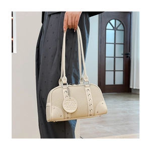 Detail of cream leather shoulder bag with pebble texture and silver metallic hardware