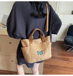 Détail du sac cabas en toile kaki montrant les poches latérales et la bandoulière