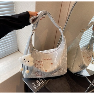 Detail of grey pleated tote bag with cat embroidery and a white cloud charm accessory