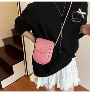 Détail du sac de téléphone rose en cuir grainé avec fermeture à bouton minimaliste