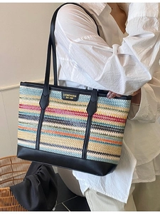 Large straw tote bag with colorful stripes and black leather straps for summer beach