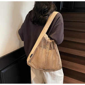 Detailed close-up of beige mesh nylon tote showing breathable hollow weave and side tag