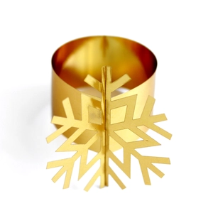 Close-up of golden metal snowflake napkin ring with polished finish for Christmas tables