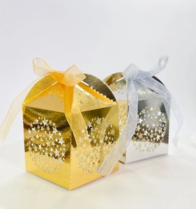 Detailed view of gold and silver laser-cut star gift boxes with organza ribbon bows