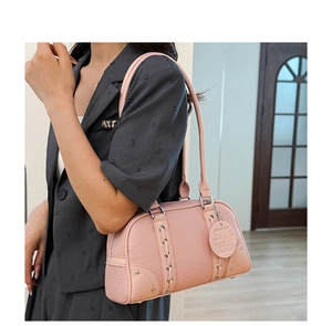 Detail of pink pebbled leather Boston bag with silver hardware and braided side accents