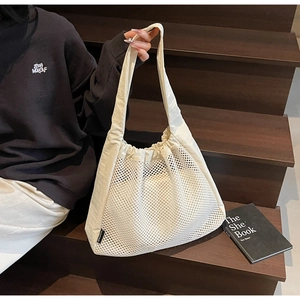 Close-up of cream mesh tote bag with hollow design and spacious interior for leisure