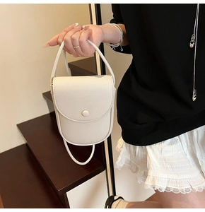 Gros plan du mini sac crème montrant la texture raffinée du cuir grainé et du rabat