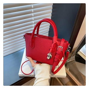 Détail du sac seau rouge texturé litchi avec breloque argentée et anses doubles