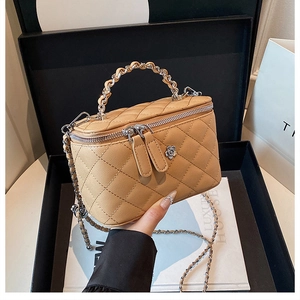 Détails du sac seau matelassé marron clair avec ornement floral argenté et bandoulière chaîne