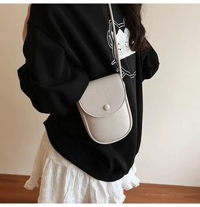 Vue détaillée du mini sac bandoulière pour téléphone en cuir crème avec sangle assortie