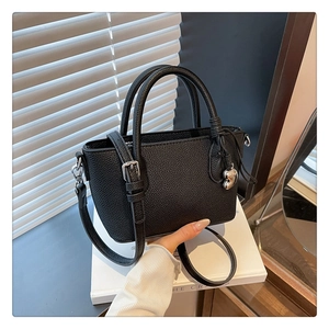 Détail du sac seau noir en cuir grainé avec boucles argentées et pendentif en cœur