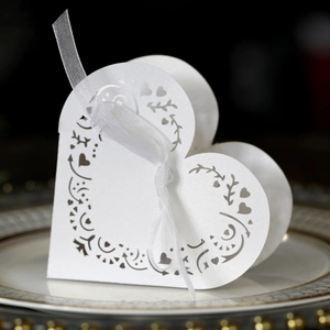 Close-up of laser-cut heart candy box on a gold-rimmed plate for wedding favors