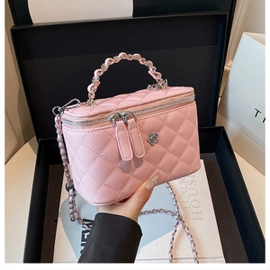 Vue détaillée de la texture du sac en cuir matelassé rose avec ornement fleur en métal