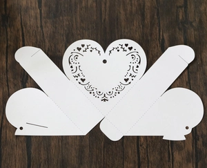 Detailed laser-cut white heart hollow design on flat gift box template for weddings