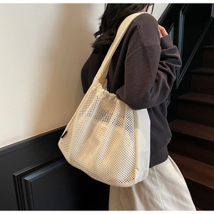 Detail of cream mesh tote bag with drawstring shoulder straps and double-layer design