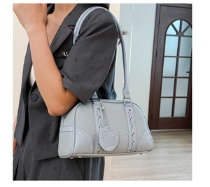 Detail of light blue-grey pebble leather bowling bag with silver rivets and woven design