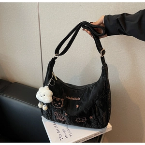 Detail of black wrinkled hobo bag with cat embroidery and a plush cloud charm