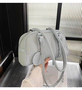 Detail of light blue pebble leather Boston bag with side lace-up design and metal zipper