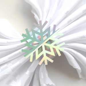 Macro view of a holographic snowflake napkin ring with a white fabric napkin