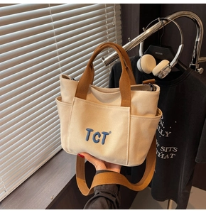 Détails du grand sac cabas en toile beige avec sangles brunes et broderie TCT