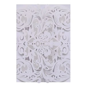 Detailed laser-cut white wedding invitation with intricate floral lace and scroll pattern