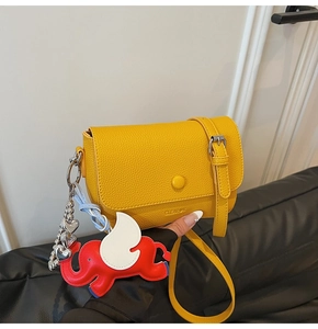 Detail of yellow lychee texture square bag with CLEARUK logo and cute elephant charm