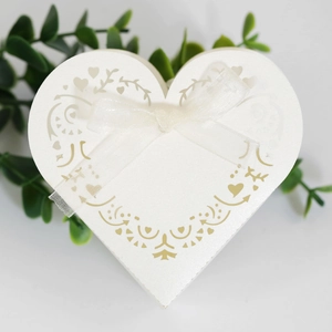 Macro detail of laser-cut heart pattern on pearlescent white wedding favor box