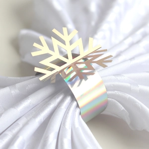 Macro shot of silver laser-cut snowflake napkin ring with iridescent metallic finish