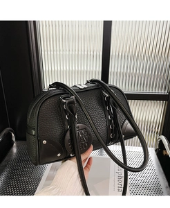 Detail of black pebbled leather Boston bag with silver studs and metal mesh background