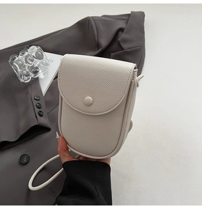 Vue détaillée de la texture grainée haut de gamme sur le sac à bandoulière blanc ivoire