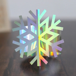 Detailed view of iridescent 3D laser-cut snowflake napkin ring on wooden surface