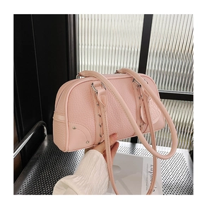 Detail of pink Boston bag showing lychee pattern leather and unique metal ring lacing
