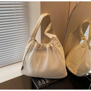 Detail of white mesh tote bag showing breathable texture and durable fabric shoulder strap