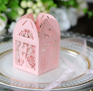 Detail of laser-cut pink wedding favor box with Mr & Mrs silhouette and silk ribbon