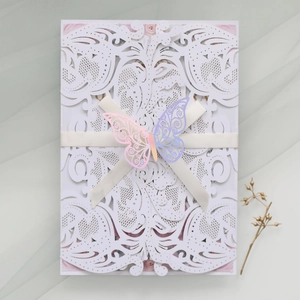 Detailed laser-cut wedding invitation with silk ribbon bow and gradient butterfly ornament