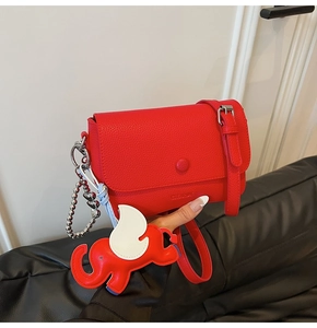 Red lychee pattern square crossbody bag with round decorative buckle and elephant charm