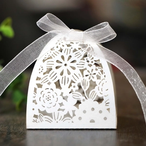Macro detail of laser-cut floral pattern on white pearlescent wedding favor gift box