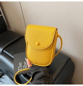 Détail du sac selle jaune en cuir PU grainé avec fermeture magnétique et bandoulière