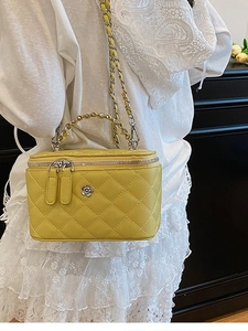 Sac seau jaune matelassé avec logo floral argenté et bandoulière en chaîne métal