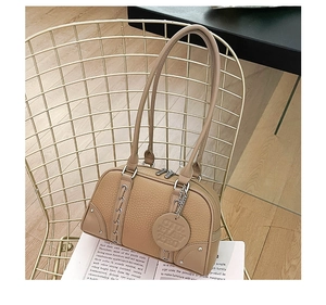 Detailed view of khaki leather Boston bag with litchi texture and silver hardware