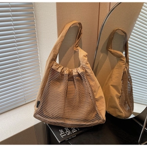 Detail of hollow nylon tote bag with drawstring closure and mesh texture in beige