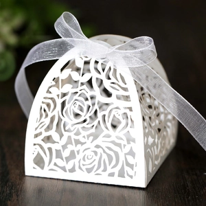 Detailed laser-cut white favor box with rose patterns and white chiffon ribbon