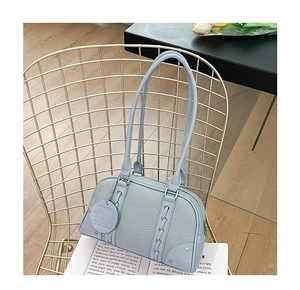 Detail of light blue lychee pattern leather shoulder bag with decorative studio tag