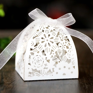 Detailed laser-cut hollow rose pattern on white wedding candy gift box with ribbon bow
