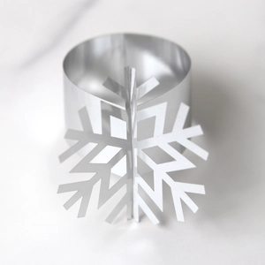 Macro shot of silver metal snowflake napkin ring with mirrored finish and 3D design